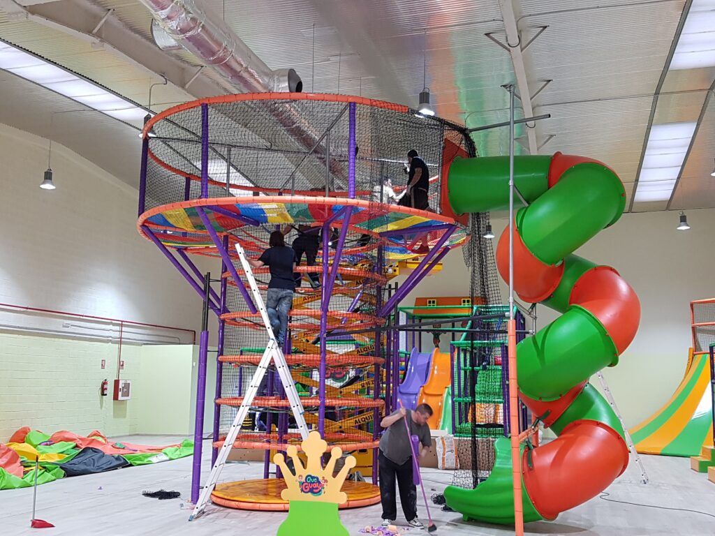 Técnicos montando una torre de redes y un tobogán en espiral