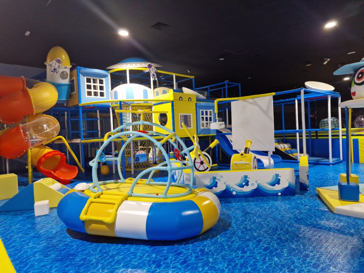 Parque infantil de interior con temática marina y suelo azul